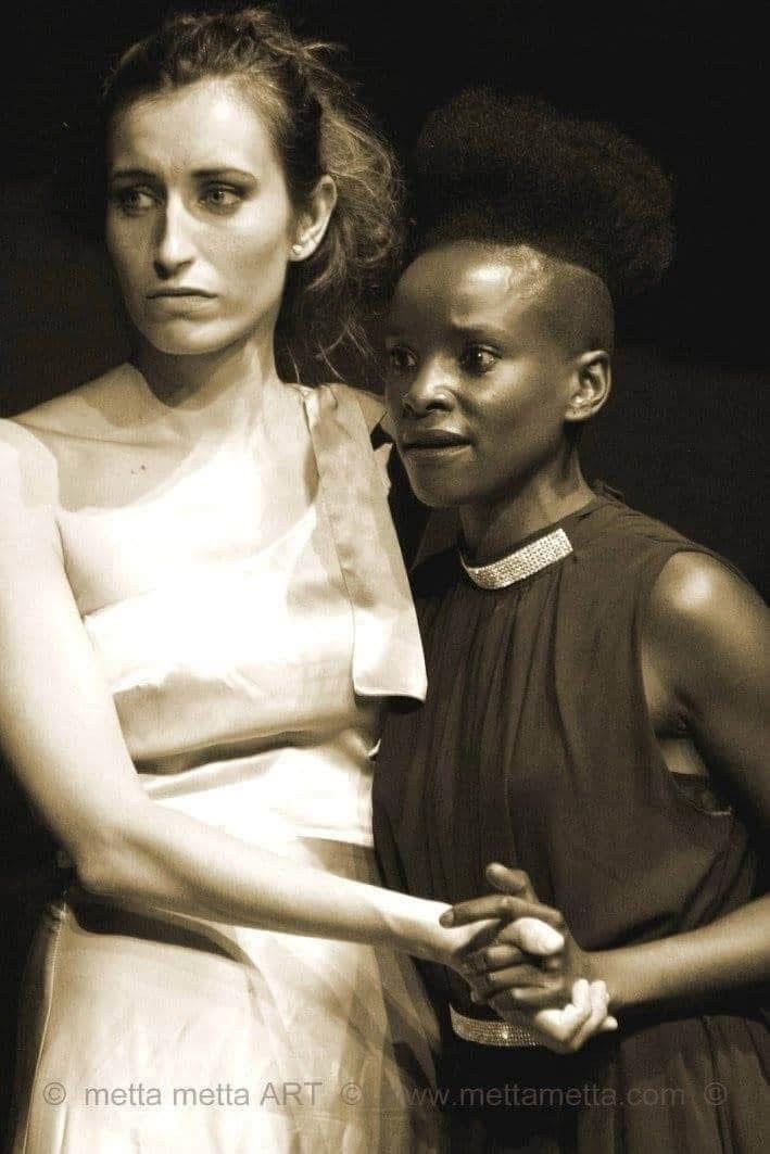 Sepia-nærbillede af to kvinder, der holder hinanden i hånden i The Merchant of Venice.