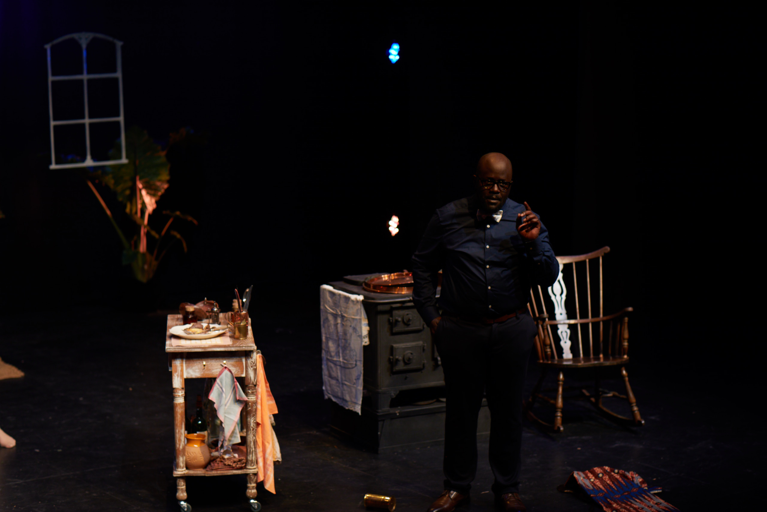 Jean alone under blue light delivering the political argument of the play.