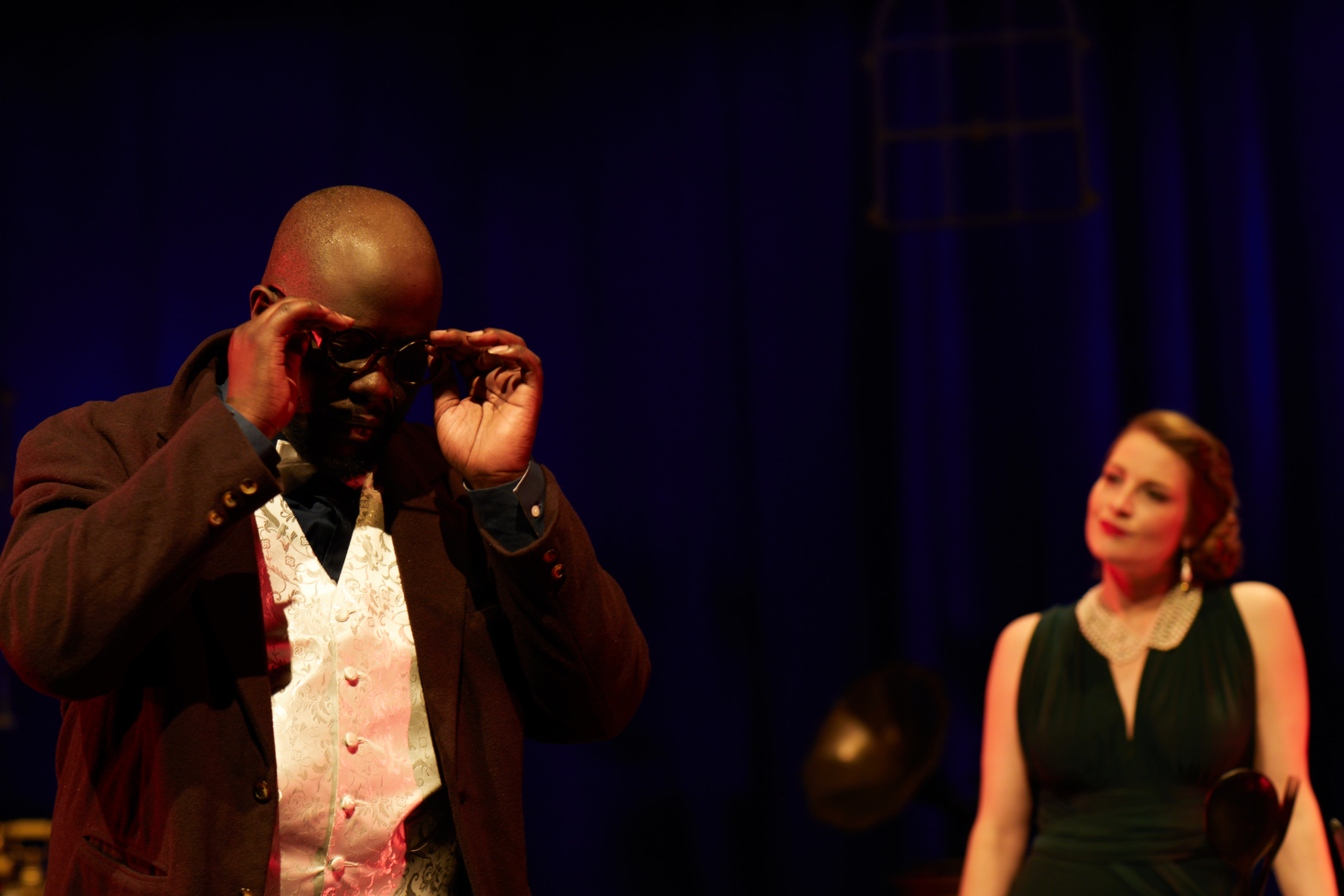 Jean adjusting his glasses while Julie looks on.