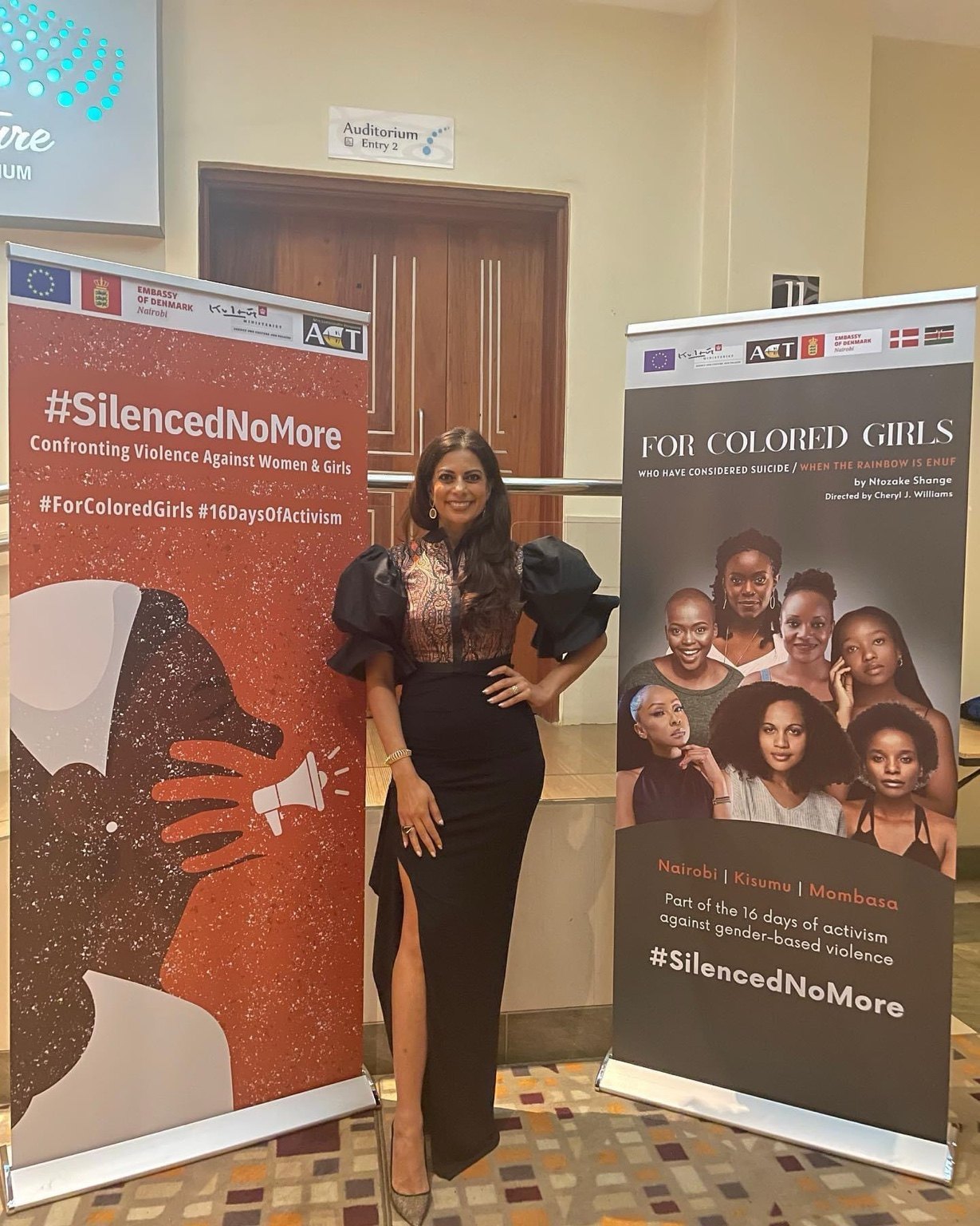 Pinky Ghelani beside Silenced No More and For Colored Girls campaign banners.