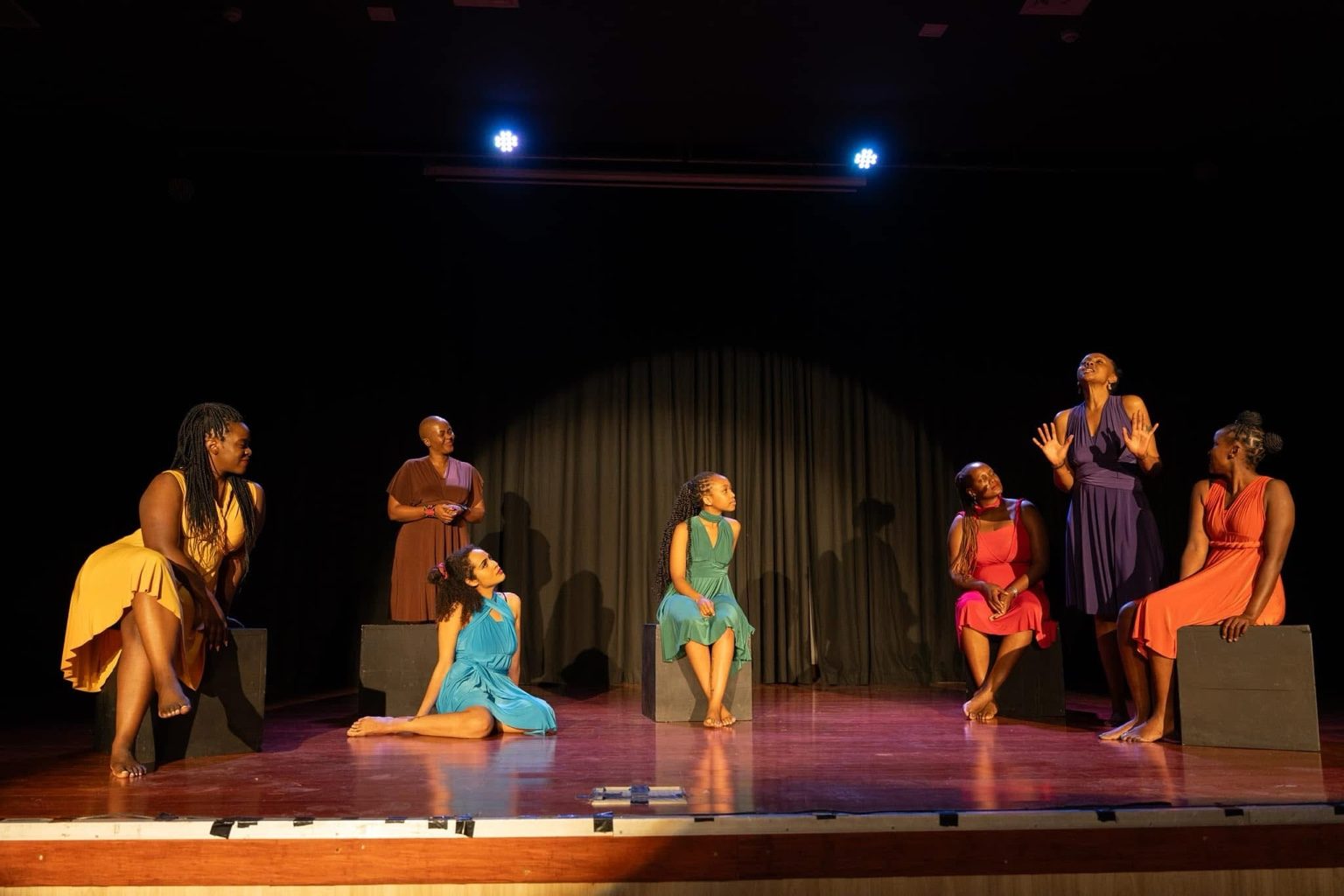 Ensemble of women resting together in a sensual collective tableau during Silenced No More.