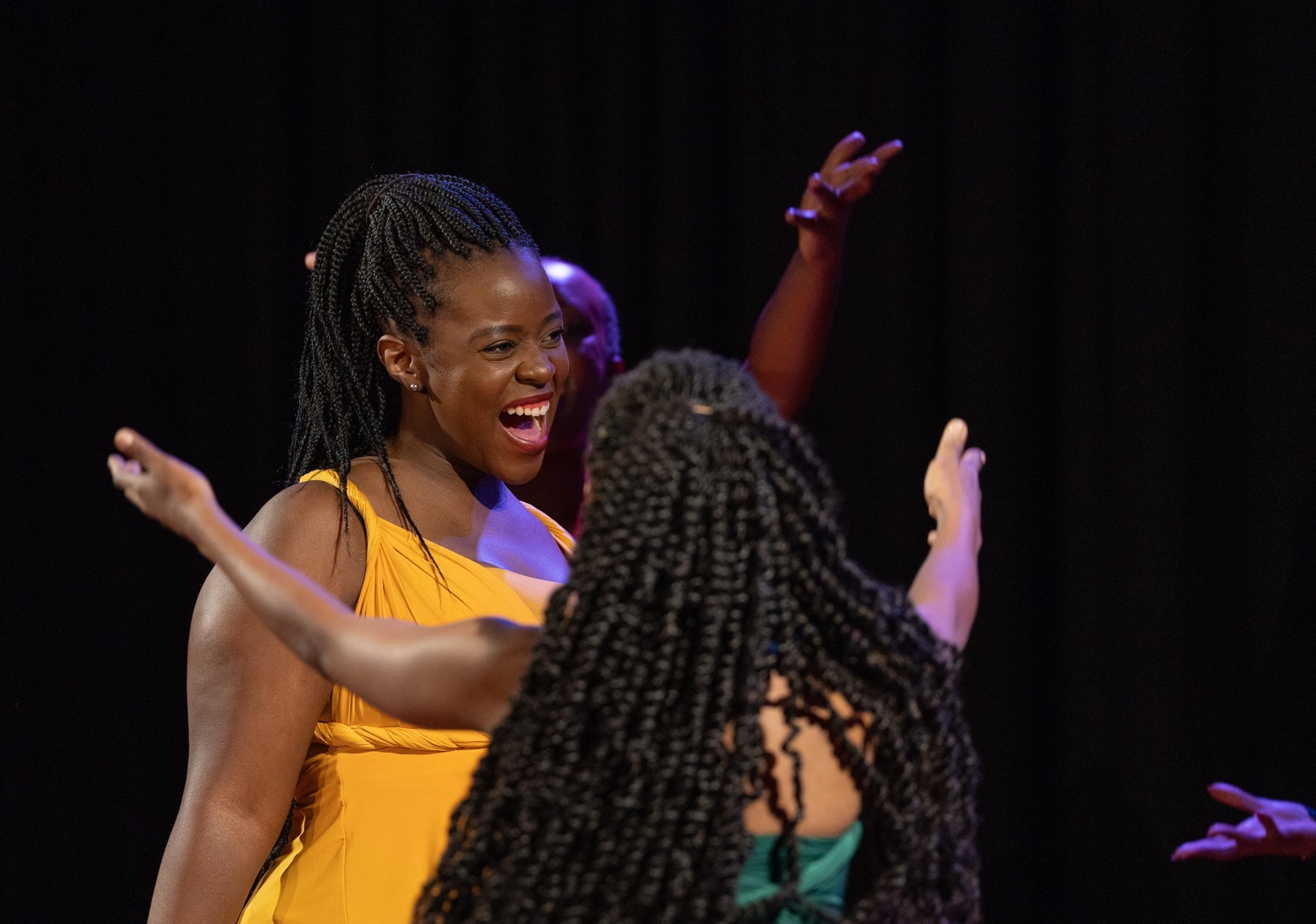 A woman in yellow laughing in close-up.